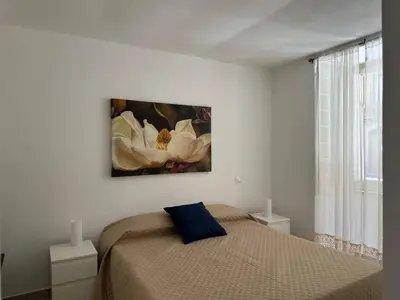 a bedroom with a bed with a painting on the wall at Soraya House Next quattrocanti in Palermo