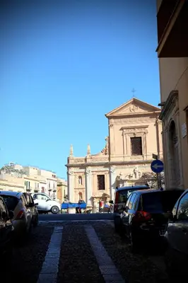 a large building with cars parked in a parking lot at Il carrettiere in Termini Imerese