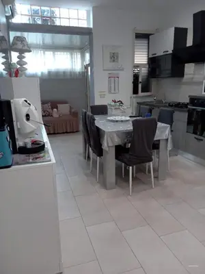 a kitchen and living room with a table and chairs at Dolce casa in Palermo