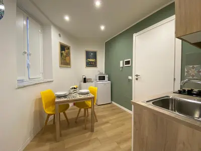 a kitchen with a table and chairs and a sink at A Casa di Jimmy in Palermo