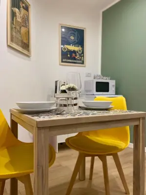 a dining room table with yellow chairs around it at A Casa di Jimmy in Palermo