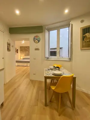 a dining room with a table and a yellow chair at A Casa di Jimmy in Palermo