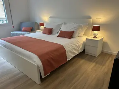 a bedroom with a large bed and a chair at Pirandello 181 in Palermo