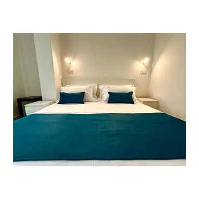 a bedroom with a large bed with two blue pillows at Pirandello 181 in Palermo