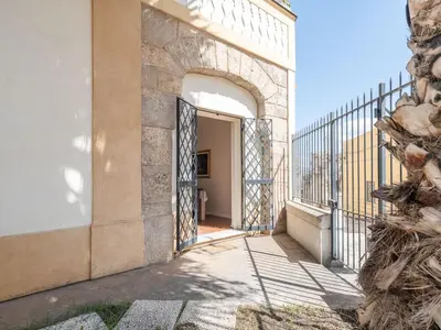 a white bedroom with a bed and a chair at Apartment in Villa Storica Lanterna sul Mare Palermo in Palermo