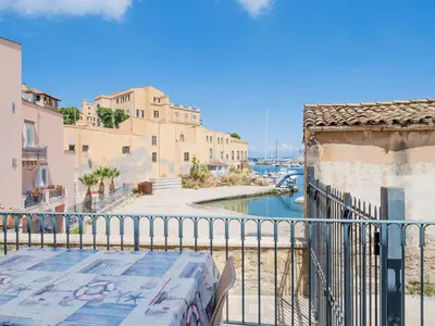 a balcony with a table and a view of a canal at Apartment in Villa Storica Lanterna sul Mare Palermo in Palermo