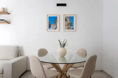 a white living room with a glass table and chairs at With love, Apartment 4 in Palermo
