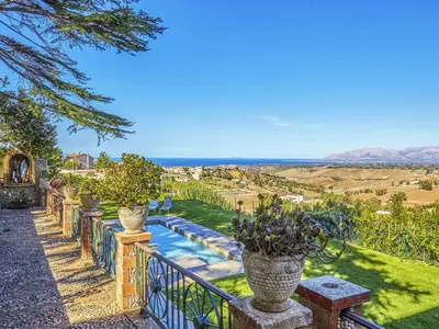 a garden with potted plants and a fence with a pool at Villa Tommaso Maruggi, Sicilia, con Jacuzzi e piscina privata in Alcamo
