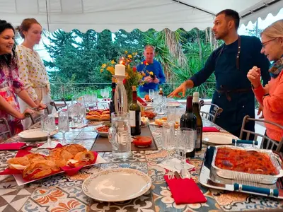 a group of people standing around a table with food at Villa Tommaso Maruggi, Sicilia, con Jacuzzi e piscina privata in Alcamo