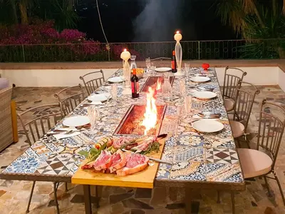 a long table with food on it with a fire at Villa Tommaso Maruggi, Sicilia, con Jacuzzi e piscina privata in Alcamo