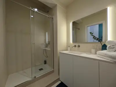 a bathroom with a shower and a sink and a mirror at Apartament and suite cavour 106 in Palermo