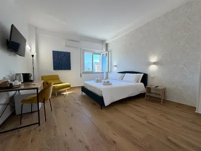 a bedroom with a bed and a table and a desk at Cinquantotto Cozy Rooms in Palermo