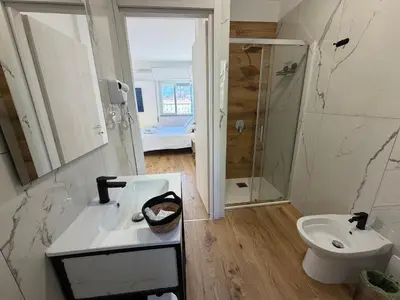 a white bathroom with a sink and a toilet at Cinquantotto Cozy Rooms in Palermo