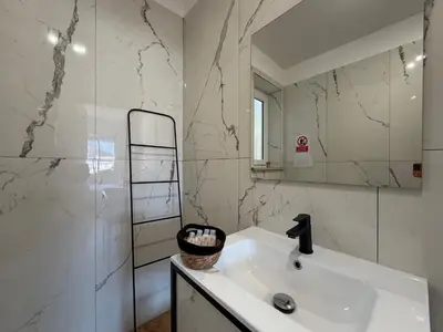 a white bathroom with a sink and a mirror at Cinquantotto Cozy Rooms in Palermo