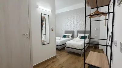 a bedroom with two beds and a mirror at Cinquantotto Cozy Rooms in Palermo