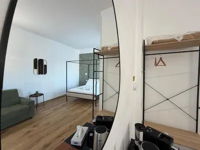 a living room with a green couch and a glass room at Cinquantotto Cozy Rooms in Palermo