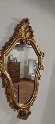 a gold mirror on a wall in a living room at Palazzo Conte Federico Apartments in Palermo