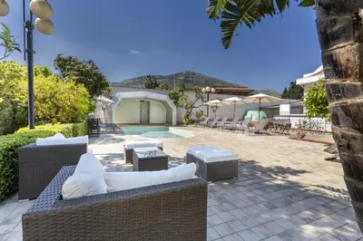a backyard with a pool and chairs and a house at Villa Sandoval in Palermo