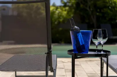 a table with a bottle and two glasses on it at Villa Sandoval in Palermo