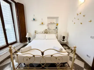 a bedroom with a white bed in a room at La Rosa Bianca della Vucciria in Palermo