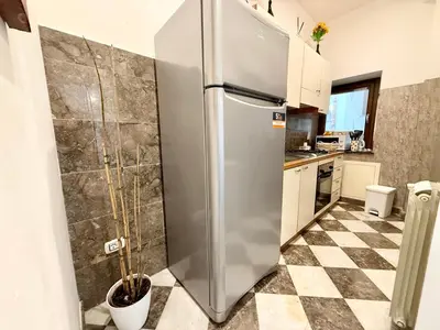 a stainless steel refrigerator in a kitchen with a checkered floor at La Rosa Bianca della Vucciria in Palermo