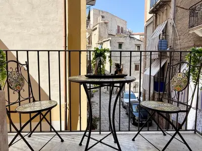 a table and two chairs on a balcony at La Rosa Bianca della Vucciria in Palermo