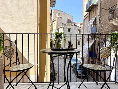 a table and two chairs on a balcony at La Rosa Bianca della Vucciria in Palermo