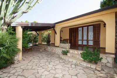 a patio of a house with a stone walkway at Villino Dei Gabbiani in Castellammare del Golfo
