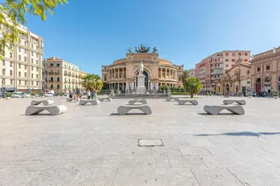 a city square with benches in front of a building at Ruggero City View apartment by Wonderful Italy in Palermo