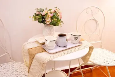 a table with two cups and a vase with flowers at La Casa di Freda in Palermo