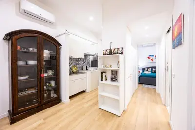 a kitchen with white cabinets and a wooden floor at La Casa di Freda in Palermo