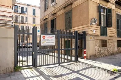 a gate in front of a building with a sign on it at Casa D'Ondes in Palermo