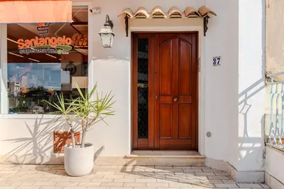 a wooden door on a white building with a potted plant at LuminArt in Nuova Gibellina