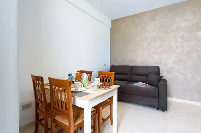 a living room with a table and chairs and a couch at Beach View Apartment in San Vito lo Capo