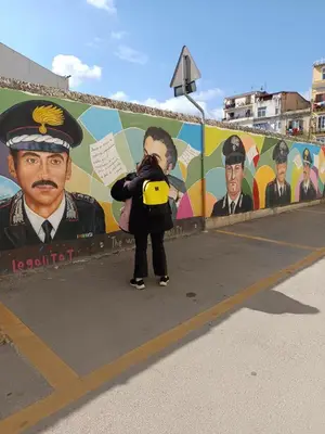 a woman taking a picture in front of a mural at Capo Petit Apartment in Palermo