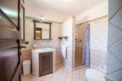 a bathroom with a sink and a shower and a toilet at Monolocale Casa Maria in San Vito lo Capo