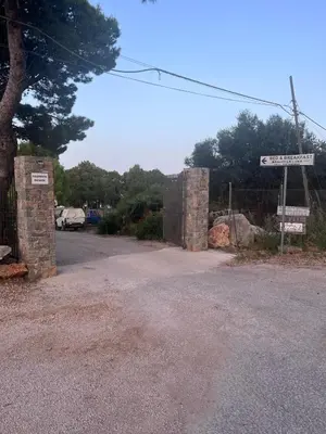 a gate with a street sign on the side of a road at Monolocale Casa Maria in San Vito lo Capo