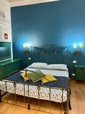 a bedroom with a bed with a blue wall at Leon in Palermo