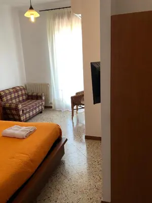 a bedroom with a bed and a couch and a television at Albergo BELVEDERE in Santa Cristina Gela