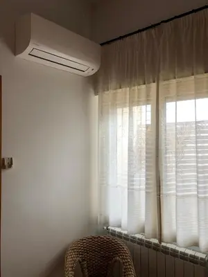 a room with a chair and a window with curtains at Albergo BELVEDERE in Santa Cristina Gela