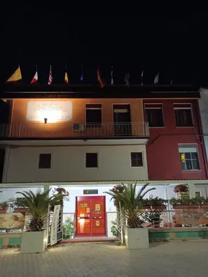 a building with a red door and a balcony at Albergo BELVEDERE in Santa Cristina Gela