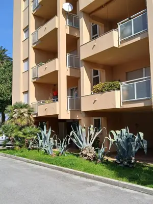 an apartment building with plants in front of it at Maison Du Parc in Palermo