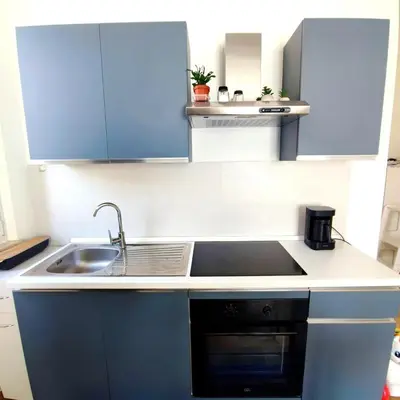 a kitchen with blue cabinets and a sink at Casa Viola - Central Apartment City & Sea in Alcamo