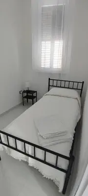 a bed in a white room with a window at Casa Viola - Central Apartment City & Sea in Alcamo