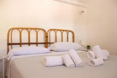 a bedroom with two beds with white pillows at Eli's Home in Terrasini