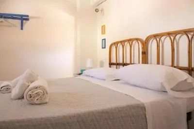 a bedroom with two beds with white sheets and towels at Eli's Home in Terrasini