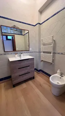 a bathroom with a sink and a toilet and a mirror at Kasa Mondello in Mondello