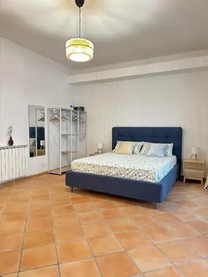 a bedroom with a blue bed and a tile floor at Kasa Mondello in Mondello