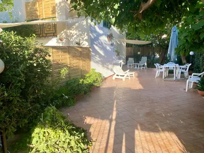 a patio with chairs and a table and umbrella at Villa Melina in Carini
