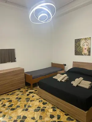 a bedroom with two beds and a chandelier at Trinacria in Capaci